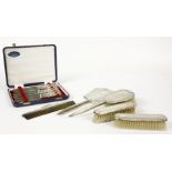 An Art Deco hallmarked silver four piece dressing table set, a similar comb and a cased set of