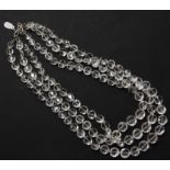 A three row graduated faceted bouton shaped rock crystal bead necklace, strung knotted to a silver