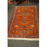 Middle Eastern rug, with red ground, symmetrical pattern with a vertical line of symmetry, blue