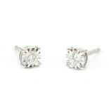 A pair of white gold single stone diamond illusion set earrings, with screw posts and butterfly