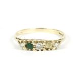 A 9ct gold five stone graduated diamond and emerald ring boat shaped ring, one emerald deficient,
