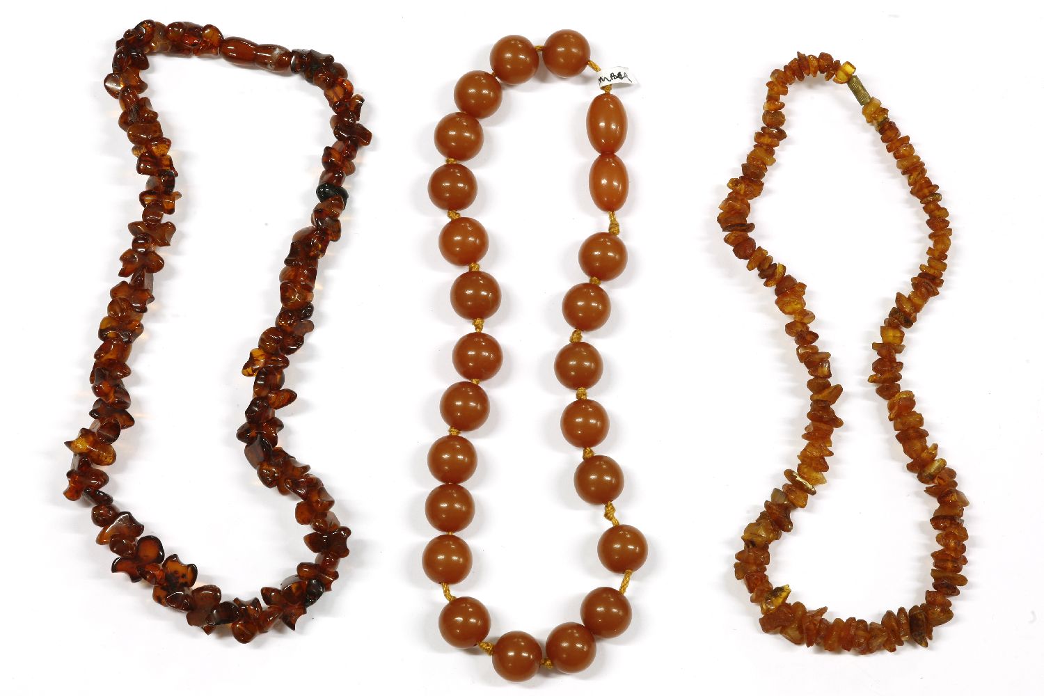Two single row freeform amber chip bead necklace, and a single row pressed early plastic bead