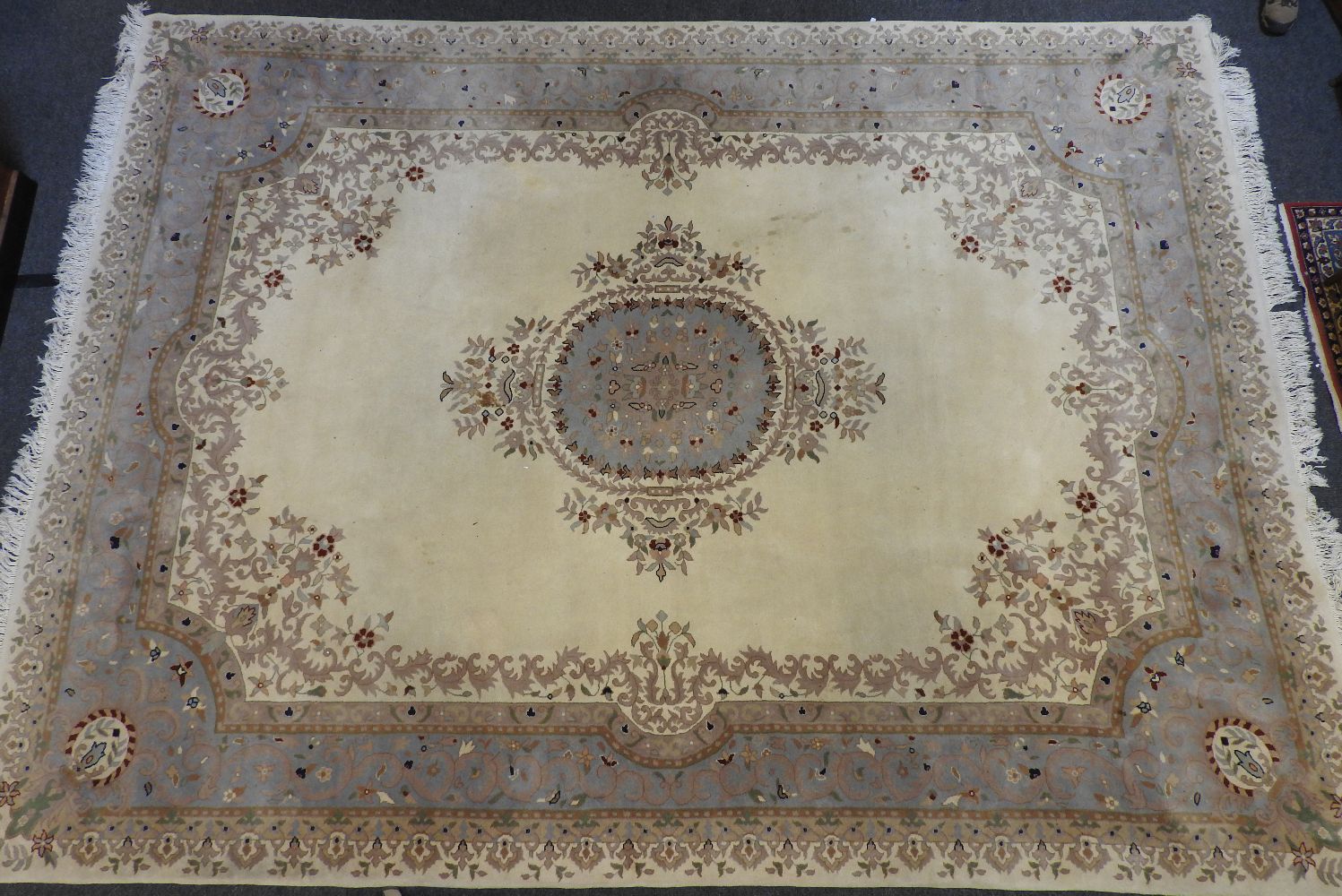 An Indian ivory ground carpet, with central pale blue medallion with conforming border, 364cm x