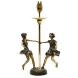 A gilt metal table lamp, modelled as two girls playing around a lamp, 38cm high