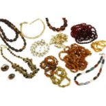 A collection of bead necklaces, including a silver banded agate brooch, a three row red glass