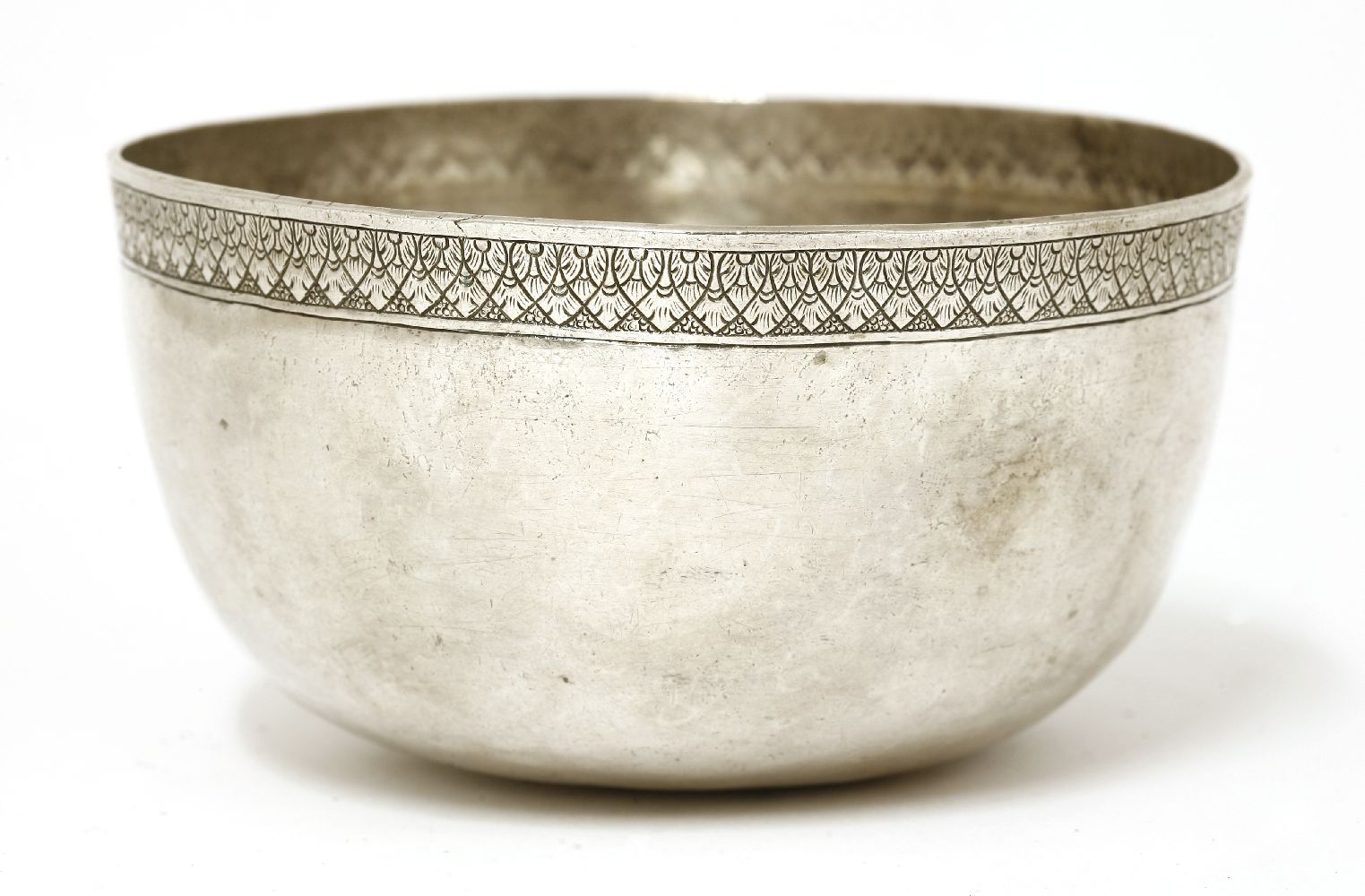 A Thai silver bowl,19th century, of circular form on a flat base, the plain body with stylised