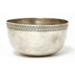 A Thai silver bowl,19th century, of circular form on a flat base, the plain body with stylised