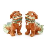 A pair of Chinese Buddhist lions,Daoguang (1821-1850), both seated, painted in red with the back fur
