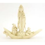 A Japanese ivory okimono.c.1920, of Kannon standing on a lotus throne on a boat, wearing elaborate