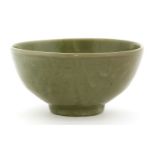A Chinese celadon bowl,Yuan-Ming dynasty, of circular form on a circular base, the thick potted body