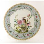 A Chinese famille rose plate, early 20th century, painted with phoenixes standing on a rock by peony