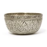 A Thai silver bowl,19th century, of circular form on a flat base, the body decorated with florets