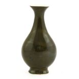 A Chinese bottle vase,18th century, of flat pear shape on an oval base, under a dark green glaze,