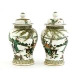 A pair of Chinese famille verte jars and covers,early 20th century, painted with an official