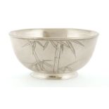 A silver bowl,early 20th century, of circular form on circular foot in two layers, decorated with