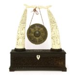 A Burmese gong stand, c.1900, the two ivory tusk supports pierced and carved with figures and