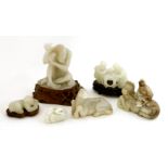 A collection of Chinese jade carvings, 20th century, comprising: a bearded man seated on the back of