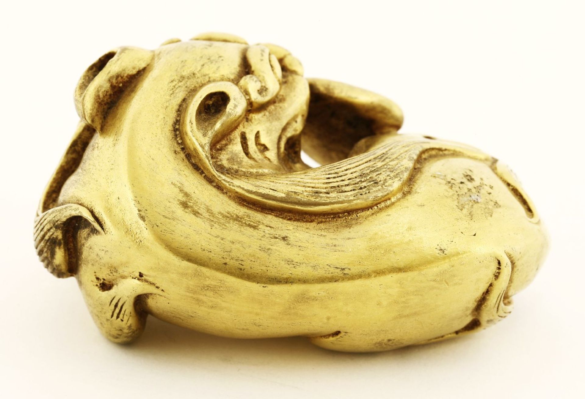 A gilt bronze paper weight, of a recumbent mythical beast, its head tilted to reach its tail, 6.5cm - Image 2 of 3