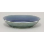 A dish,18th century, covered in an uneven, bubbled, blue glaze, the exterior yellowy-green, a