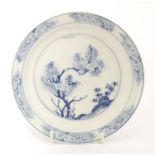 A Chinese blue and white dish,Kangxi (1662-1722), of circular form with stepped side, painted with