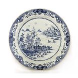 A Chinese blue and white charger, Qianlong (1736-1795), painted with buildings by a river, a