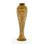 A Moorcroft Florian ware vase, with a brown neck, a green and pink ground, with raised white motifs,