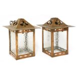 A pair of copper hall lanterns,with pierced details, mounted with mottled glass panels, one