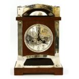 A Continental oak and silver-plated mantel clock,the embossed dial with Arabic numerals, over a