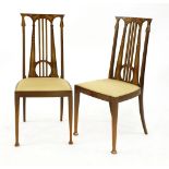 A pair of Art Nouveau mahogany inlaid hall chairs, each with pieced lyre backs and an overstuffed