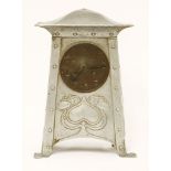 An Art Nouveau aluminium mantel clock,with a shaped top over a tapering embossed and riveted case,