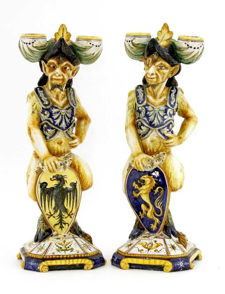 Two Cantagalli maiolica pottery candlesticks,each modelled as a faun wearing a helmet, holding a