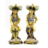 Two Cantagalli maiolica pottery candlesticks,each modelled as a faun wearing a helmet, holding a