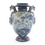 A Cantagalli blue and white pottery urn,painted with figures in a landscape, with eagle head handles
