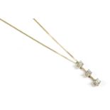 A gold three stone diamond bar pendant, suspended on a gold chase chain, pendant marked 375 (