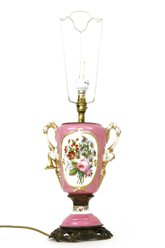 A twin handled vase form porcelain table lamp, the pink ground with landscape decorated reserve,