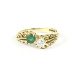 An 18ct gold emerald and diamond crossover ring, by Tom O'Donahue, with scrolling shoulders,