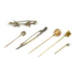 A collection of stick pins, to include two oriental gold character mark stick pins by Wang Hing,