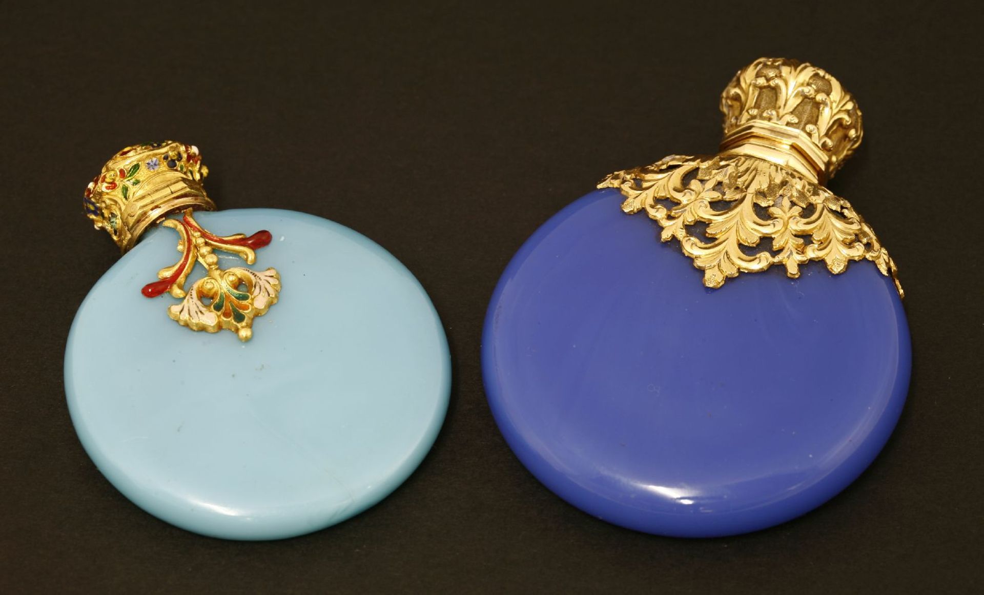 Two Victorian blue glass scent bottles,of disc shape, each with ornate gilt metal mounts and