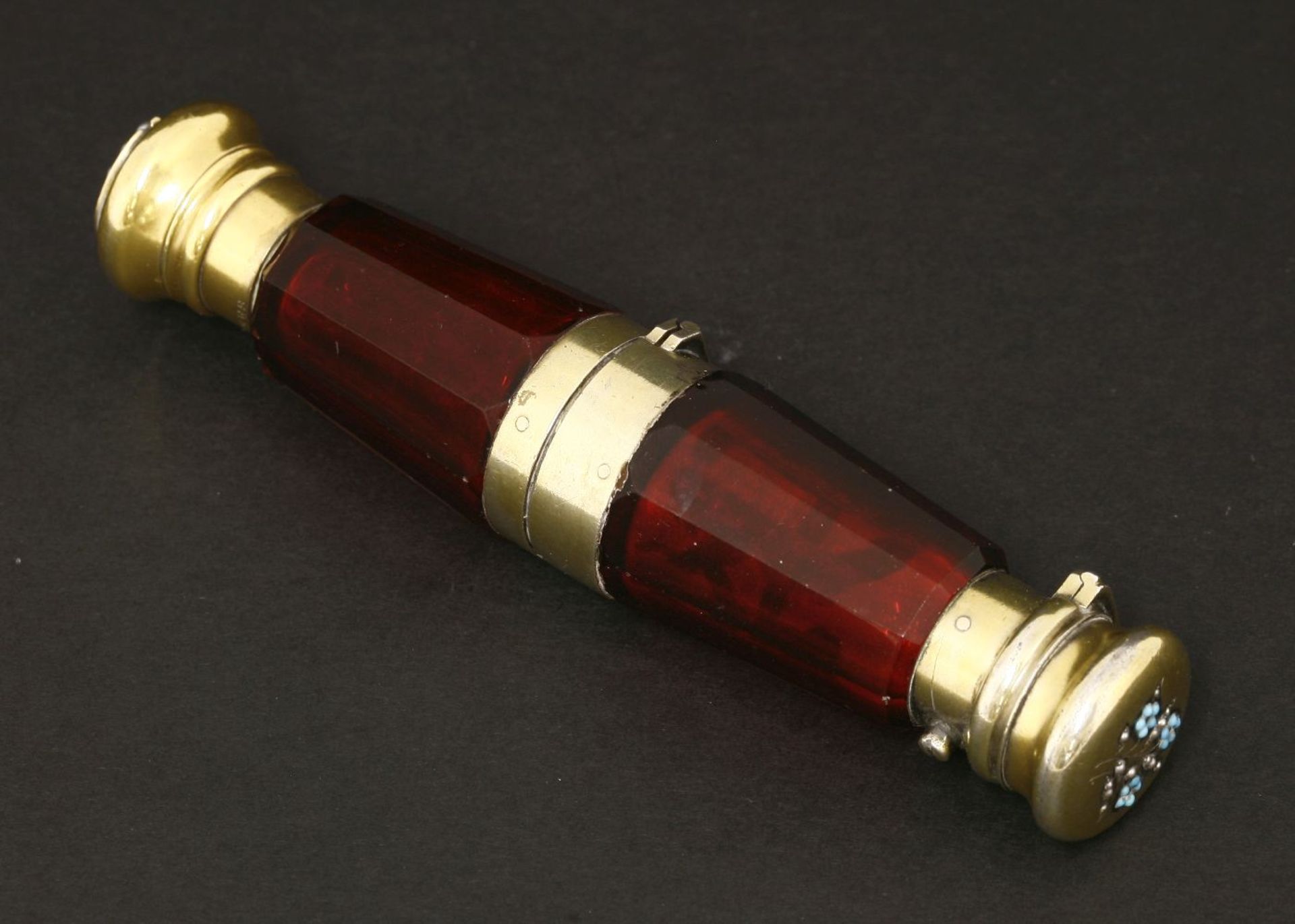 A Victorian ruby glass double-ended scent bottle and vinaigrette,the facet cut body with a central