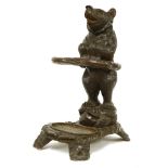 A Black Forest carved umbrella stand,modelled as a bear standing on its hind legs, holding the