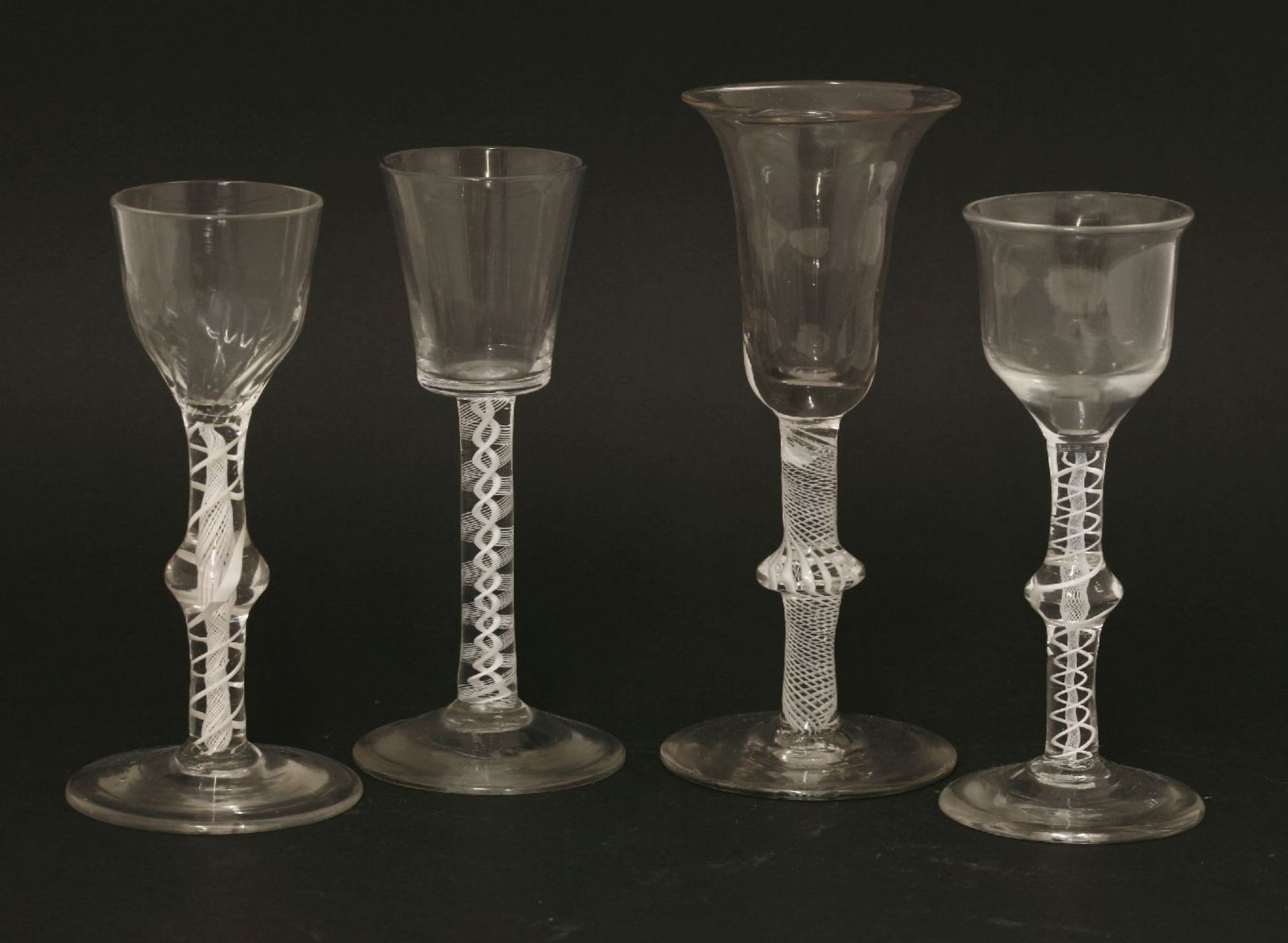 Four George III wine glasses,with opaque twist stems,one with a waisted bell-shaped bowl on a