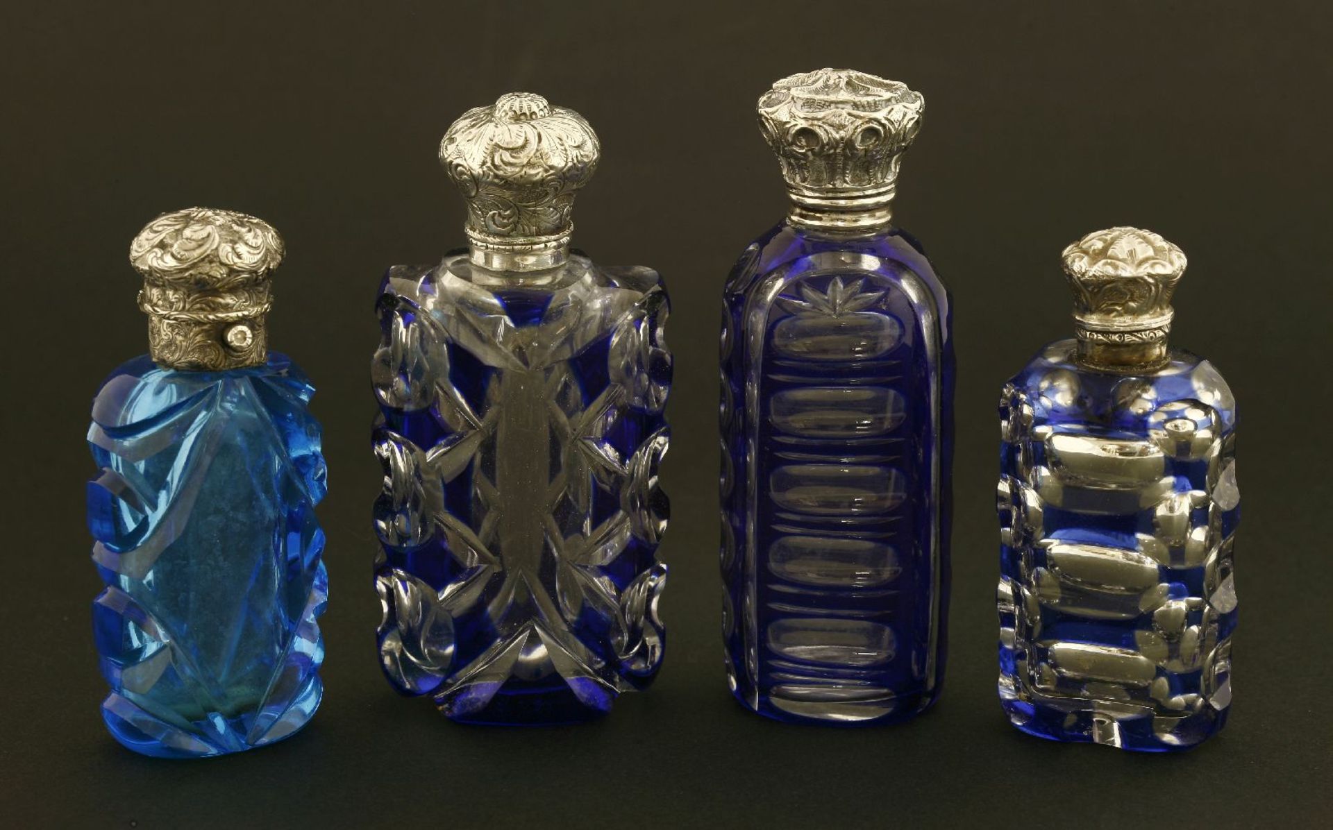 Three Bohemian blue and clear glass scent bottles,with cut decoration below ornate hinted white