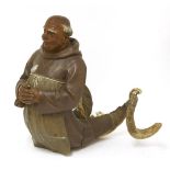 A Black Forest carved sign,modelled as a monk, his hands clasped in prayer, a spoon tucked into