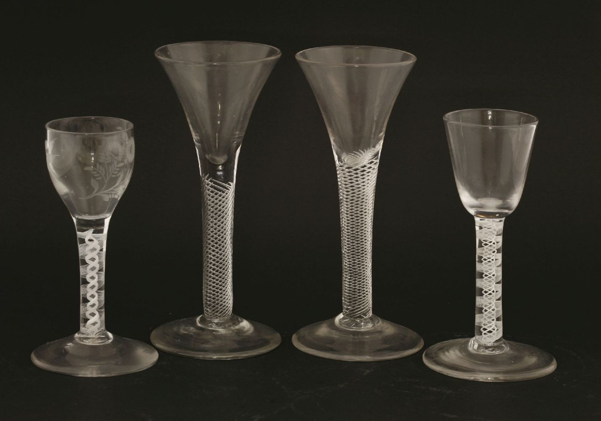 Four George III wine glasses,one with an ogee bowl engraved with a bird in flight and a floral spray