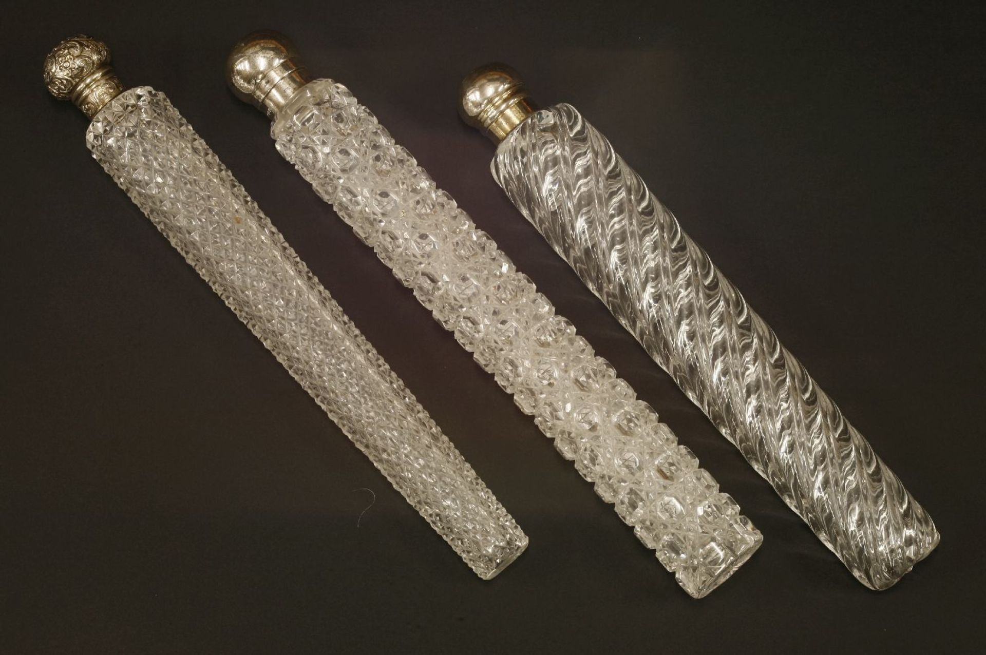 Three large glass scent bottles,one with a silver cover and a hobnail cut body,London 1884,29cm