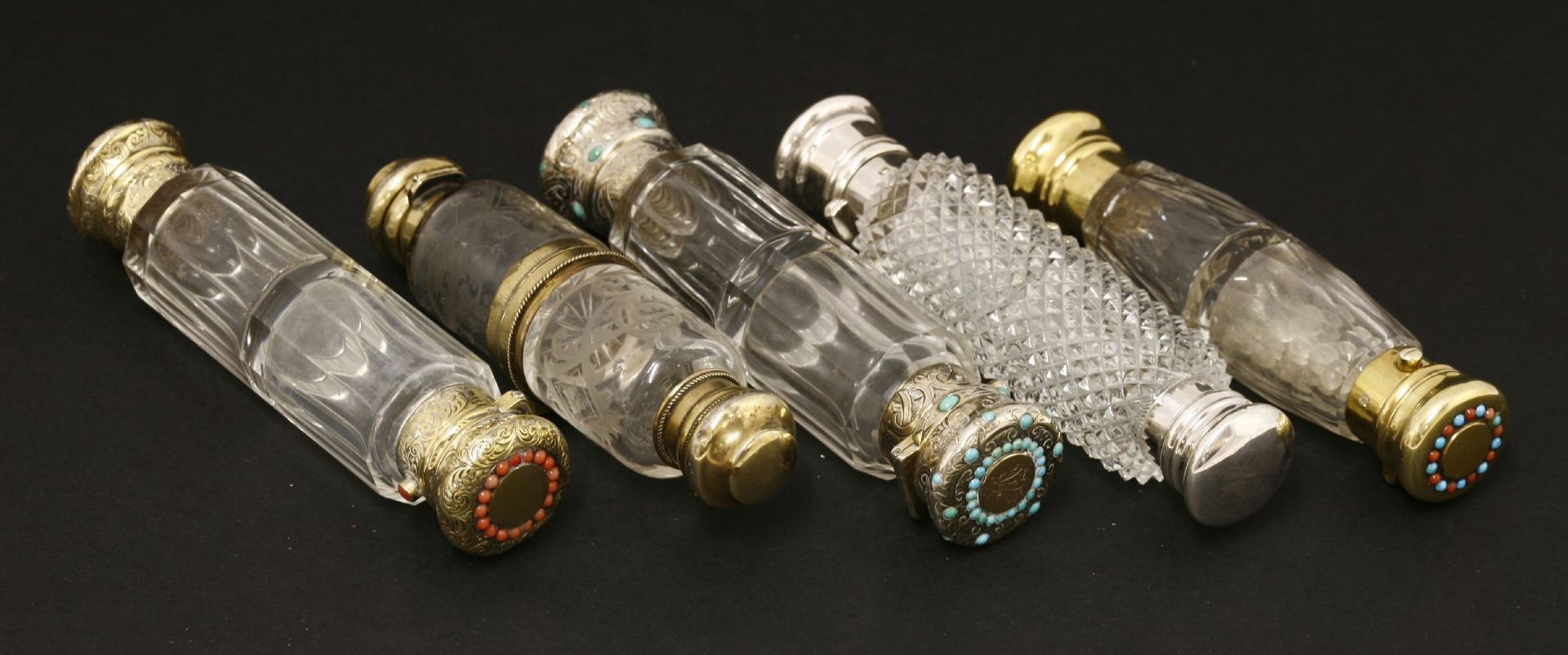 Five Victorian glass double-ended scent bottles,with white and gilt metal mounts,one inset with