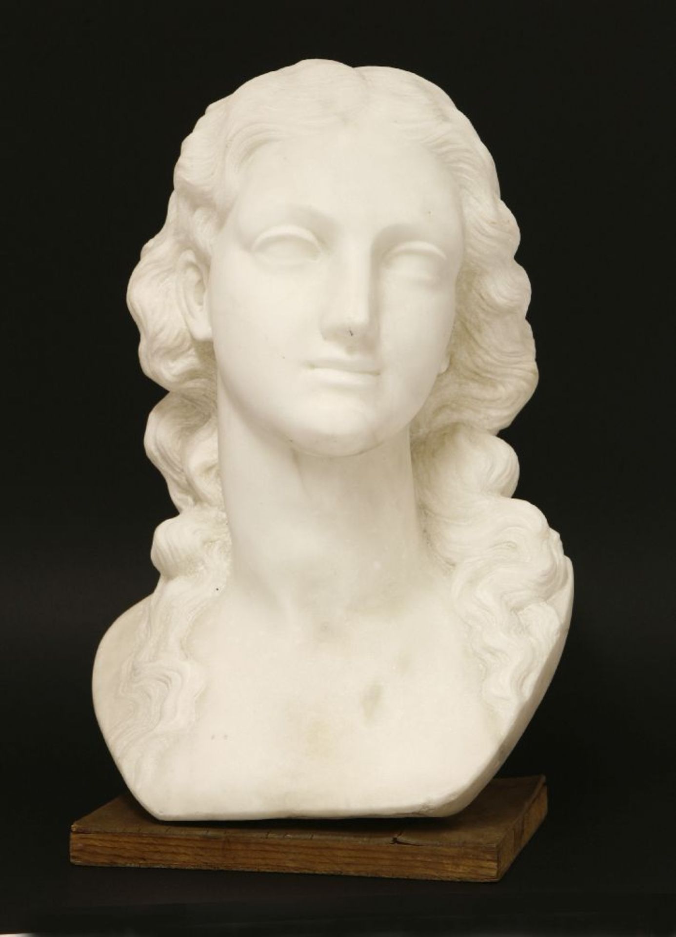 A marble bust,20th century, of a lady with flowing hair, on a plywood plinth,38cm high