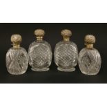 Two pairs of Victorian cut glass cologne bottles with silver covers,probably Edward Dimes, London