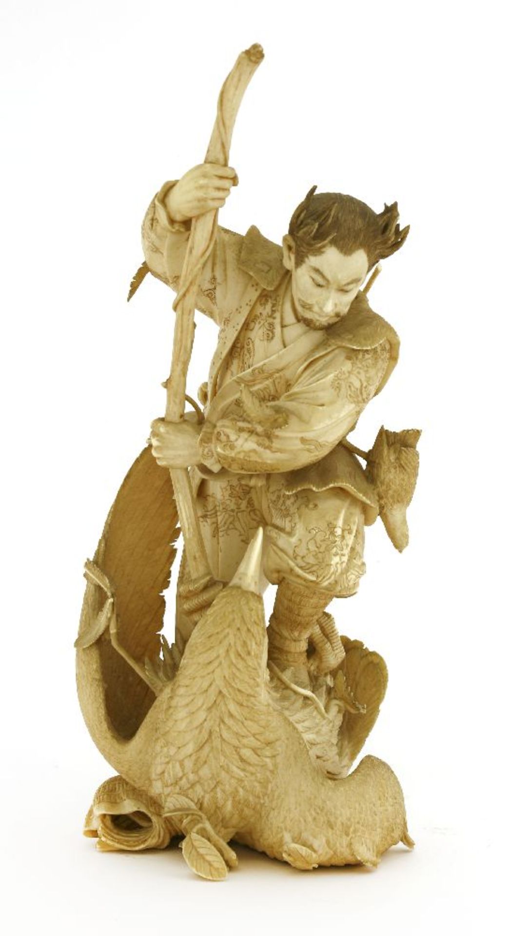 A Japanese ivory okimono,Meiji period, (1868-1912), of a hunter stabbing an eagle with a staff,