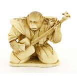 A Japanese ivory okimono,Meiji period (1868-1912), depicting a kneeled monkey playing a shamisen,